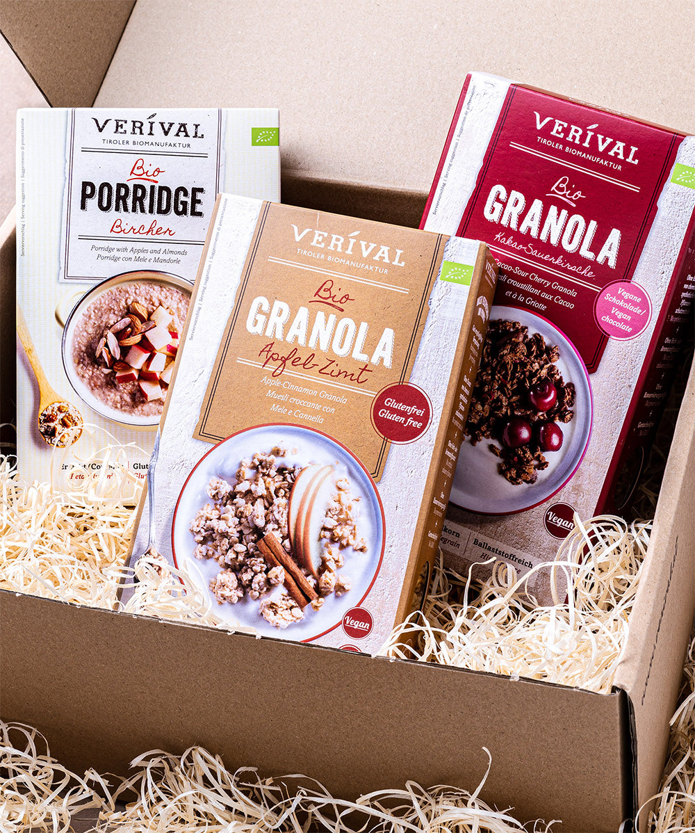 Das Set „All I Want For Breakfast“ von Verival Bio besteht aus einer Kartonbox mit Füllung aus Holzwolle und enthält veganes, glutenfreies Bio-Porridge und Granola. Zur Auswahl stehen unter anderem Bircher-Porridge, Apfel-Zimt-Granola und Kakao-Sauerkirsche Granola.