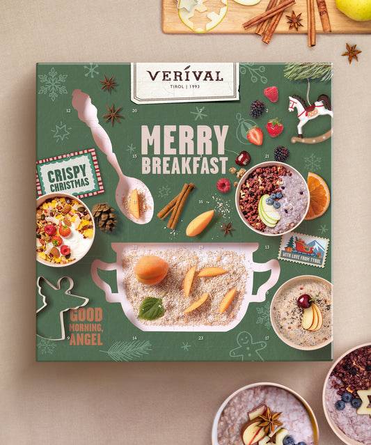 Eine festlich-grüne Adventskalender-Box von Verival Bio GmbH mit Vollkornmüsli, Obst, Nüssen, weihnachtlichen Motiven, den Aufschriften „Crispy Christmas“ und „Good Morning, Angel“, Adventskalender-Motiven sowie der Abbildung eines großen Löffels.